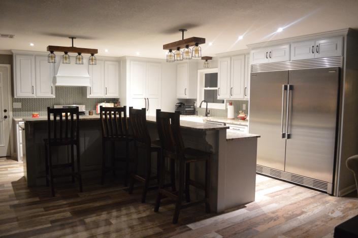 By installing new sleek lighting fixtures and adding a unique backsplash, we've brought life back into this kitchen!